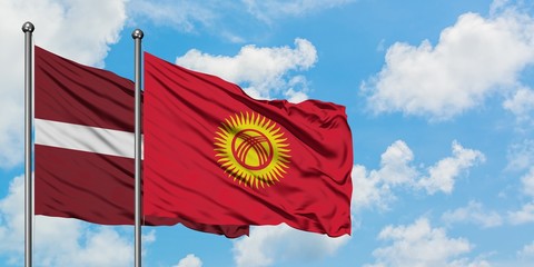 Latvia and Kyrgyzstan flag waving in the wind against white cloudy blue sky together. Diplomacy concept, international relations.