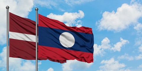 Latvia and Laos flag waving in the wind against white cloudy blue sky together. Diplomacy concept, international relations.