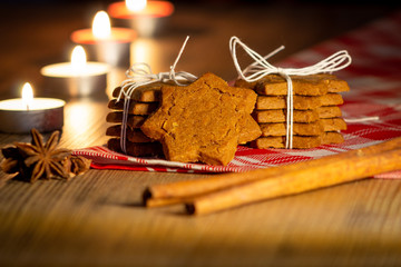 pila di biscotti legati con spago, cannella, chiodi di garofano e candele accese © roberto