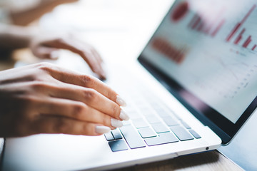 Female hands typing on laptop keyboard