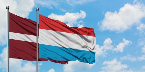 Latvia and Luxembourg flag waving in the wind against white cloudy blue sky together. Diplomacy concept, international relations.