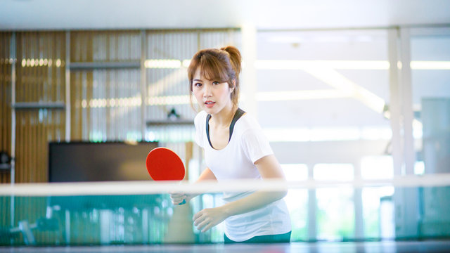 Attractive Asian Woman Playing Table Tennis ( Ping Pong ) In Sport Club