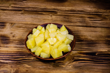 Ceramic plate with chopped canned pineapple on wooden table