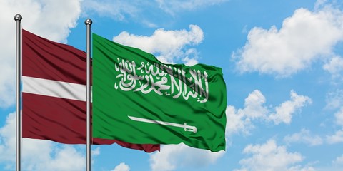 Latvia and Saudi Arabia flag waving in the wind against white cloudy blue sky together. Diplomacy concept, international relations.