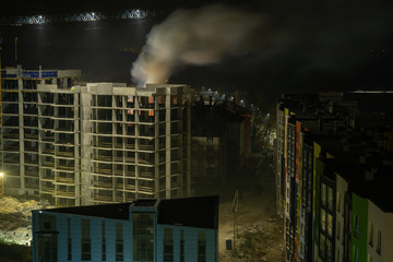 Fire behind the construction of an unfinished house. Emergency at night in the town 