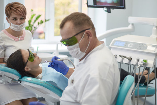 Doctor dentist treats teeth of a beautiful young girl patient. The girl on reception at the dentist. Doctor dentist treats tooth