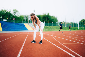Fototapeta premium Young fit woman having rest in stadium