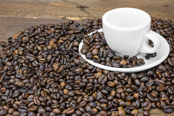 Coffee beans with cup on wooden background