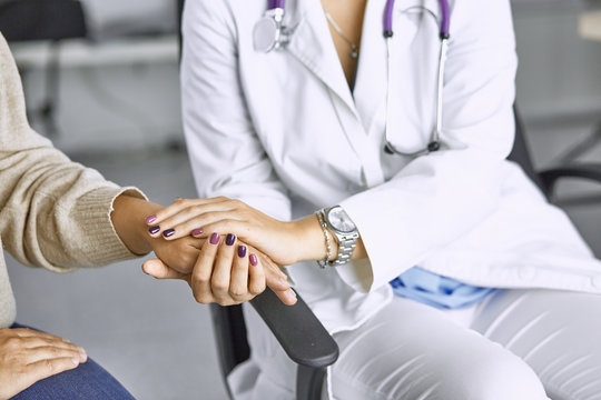 Woman Doctor Calms Patient And Holds Hand