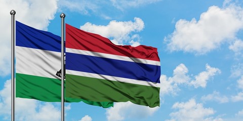Lesotho and Gambia flag waving in the wind against white cloudy blue sky together. Diplomacy concept, international relations.