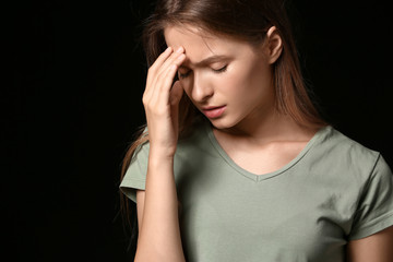 Stressed young woman on dark background