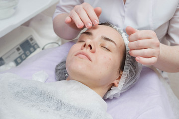 Fototapeta na wymiar A cosmetologist does an ultrasonic cleaning of the skin of the face.