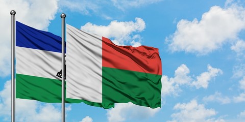 Lesotho and Madagascar flag waving in the wind against white cloudy blue sky together. Diplomacy concept, international relations.