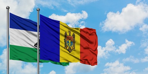 Lesotho and Moldova flag waving in the wind against white cloudy blue sky together. Diplomacy concept, international relations.