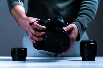 photographer equipment, cameras, lenses and hand reaching out to them