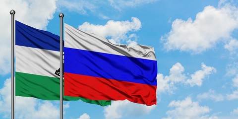 Lesotho and Russia flag waving in the wind against white cloudy blue sky together. Diplomacy...