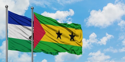 Lesotho and Sao Tome And Principe flag waving in the wind against white cloudy blue sky together....