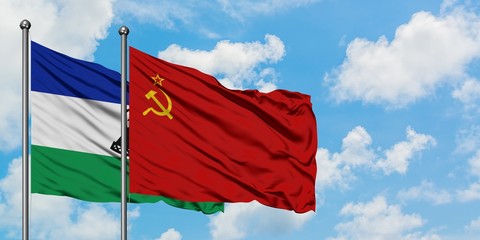 Lesotho and Soviet Union flag waving in the wind against white cloudy blue sky together. Diplomacy concept, international relations.
