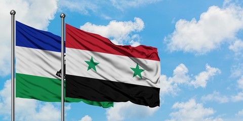Lesotho and Syria flag waving in the wind against white cloudy blue sky together. Diplomacy concept, international relations.