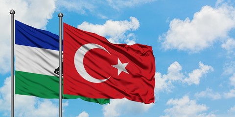 Lesotho and Turkey flag waving in the wind against white cloudy blue sky together. Diplomacy...