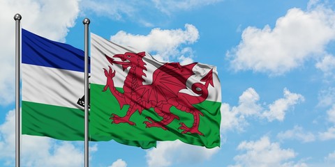 Lesotho and Wales flag waving in the wind against white cloudy blue sky together. Diplomacy concept, international relations.