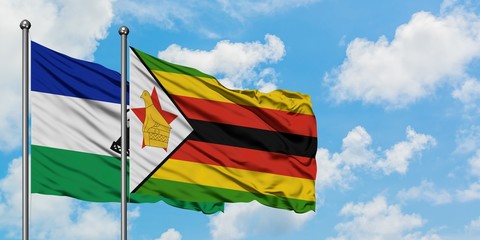 Lesotho and Zimbabwe flag waving in the wind against white cloudy blue sky together. Diplomacy concept, international relations.
