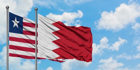 Liberia and Bahrain flag waving in the wind against white cloudy blue sky together. Diplomacy concept, international relations.