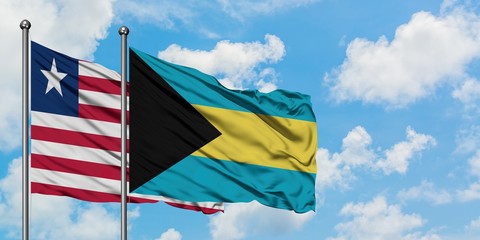 Liberia and Bahamas flag waving in the wind against white cloudy blue sky together. Diplomacy concept, international relations.