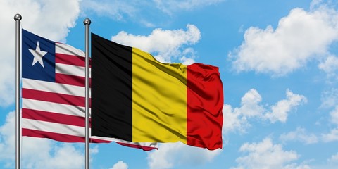 Liberia and Belgium flag waving in the wind against white cloudy blue sky together. Diplomacy concept, international relations.