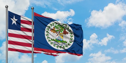 Liberia and Belize flag waving in the wind against white cloudy blue sky together. Diplomacy...