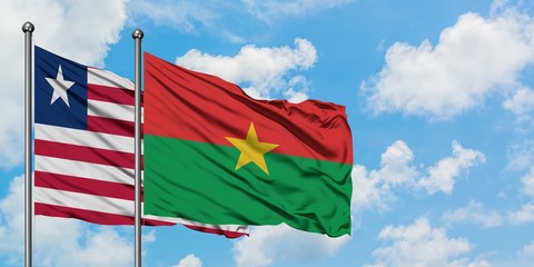 Liberia and Burkina Faso flag waving in the wind against white cloudy blue sky together. Diplomacy concept, international relations.