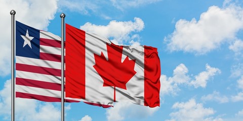 Liberia and Canada flag waving in the wind against white cloudy blue sky together. Diplomacy concept, international relations.