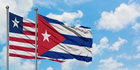 Liberia and Cuba flag waving in the wind against white cloudy blue sky together. Diplomacy concept, international relations.