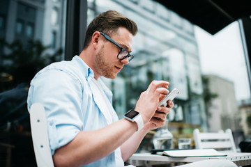 Contemporary man using mobile phone on street