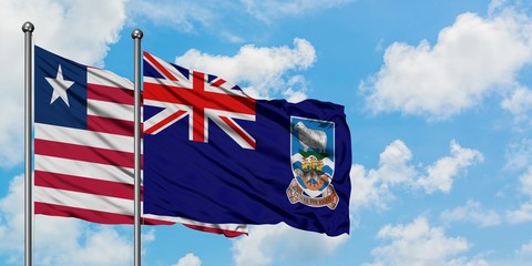 Liberia and Falkland Islands flag waving in the wind against white cloudy blue sky together. Diplomacy concept, international relations.