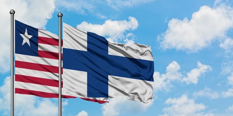 Liberia and Finland flag waving in the wind against white cloudy blue sky together. Diplomacy concept, international relations.