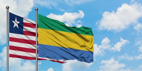 Liberia and Gabon flag waving in the wind against white cloudy blue sky together. Diplomacy concept, international relations.