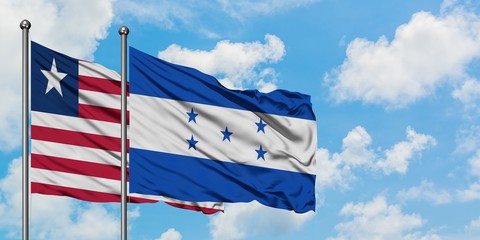 Liberia and Honduras flag waving in the wind against white cloudy blue sky together. Diplomacy concept, international relations.