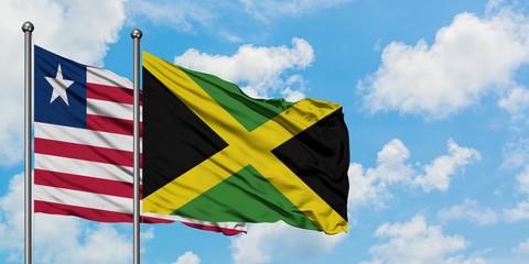 Liberia and Jamaica flag waving in the wind against white cloudy blue sky together. Diplomacy concept, international relations.