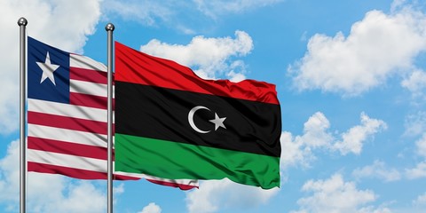 Liberia and Libya flag waving in the wind against white cloudy blue sky together. Diplomacy concept, international relations.