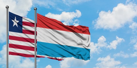 Liberia and Luxembourg flag waving in the wind against white cloudy blue sky together. Diplomacy concept, international relations.