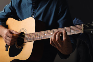 Fototapeta na wymiar Handsome man playing guitar, closeup