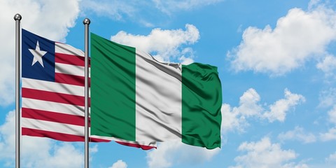 Liberia and Nigeria flag waving in the wind against white cloudy blue sky together. Diplomacy concept, international relations.