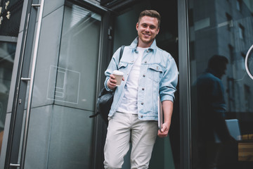Smiling man with coffee cup on street