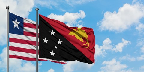 Liberia and Papua New Guinea flag waving in the wind against white cloudy blue sky together. Diplomacy concept, international relations.