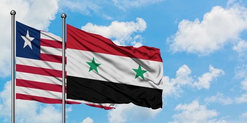 Liberia and Syria flag waving in the wind against white cloudy blue sky together. Diplomacy concept, international relations.
