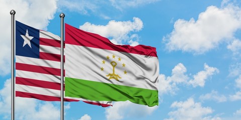 Liberia and Tajikistan flag waving in the wind against white cloudy blue sky together. Diplomacy concept, international relations.