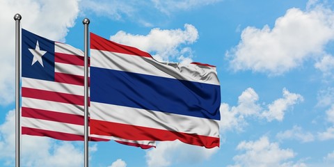 Liberia and Thailand flag waving in the wind against white cloudy blue sky together. Diplomacy concept, international relations.