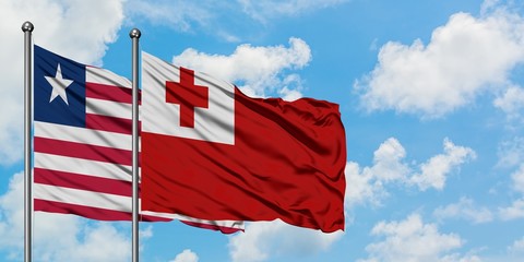 Liberia and Tonga flag waving in the wind against white cloudy blue sky together. Diplomacy concept, international relations.