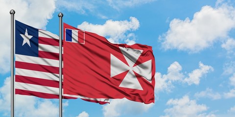 Liberia and Wallis And Futuna flag waving in the wind against white cloudy blue sky together. Diplomacy concept, international relations.